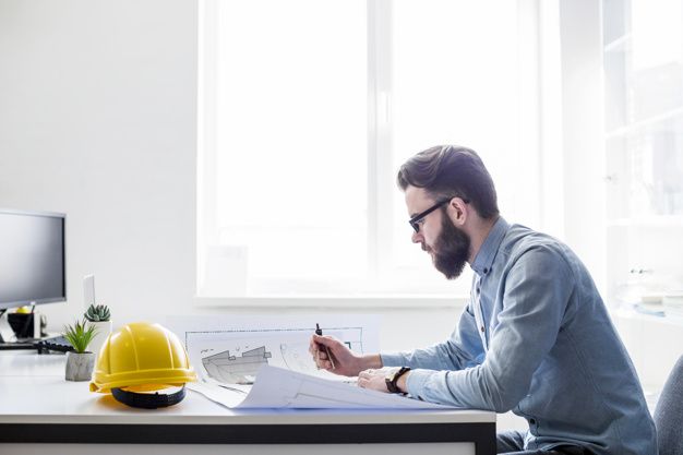 ingeniero-creativo-trabajando-en-planos-de-construccion-en-el-lugar-de-trabajo_23-2147842988